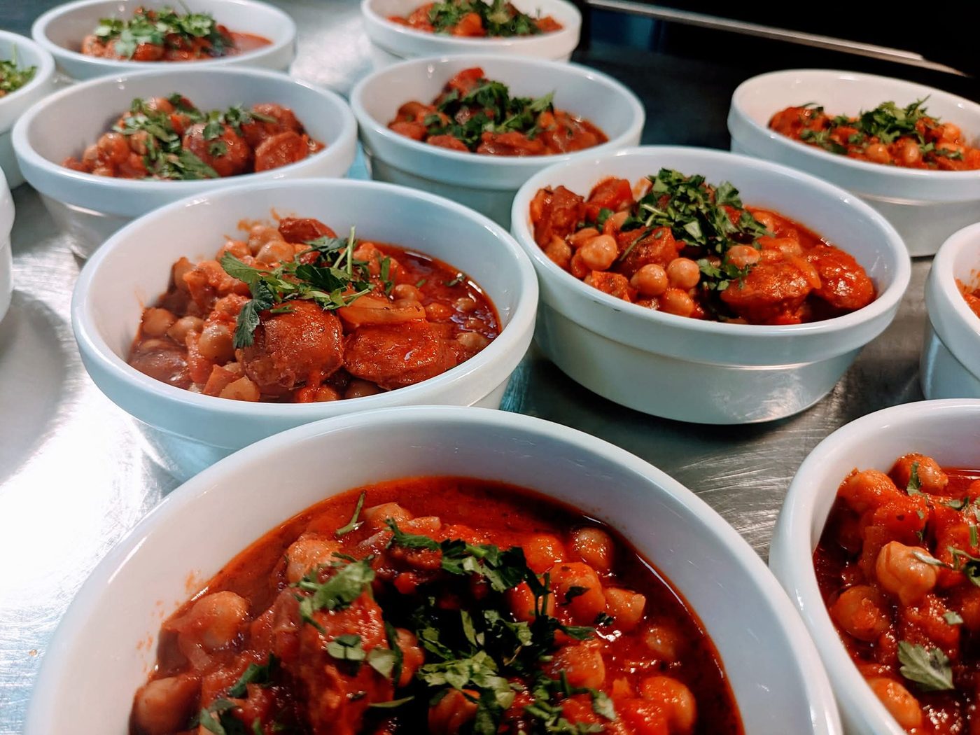 Bowls of chorizo and chickpea stew plated for service